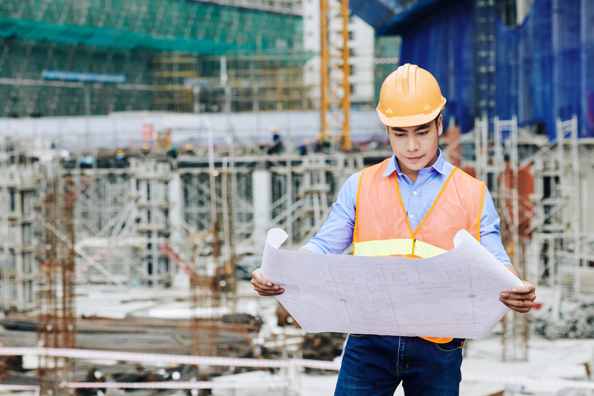Engenheiro civil analisando a planta de um edifício - Construção Civil 2020