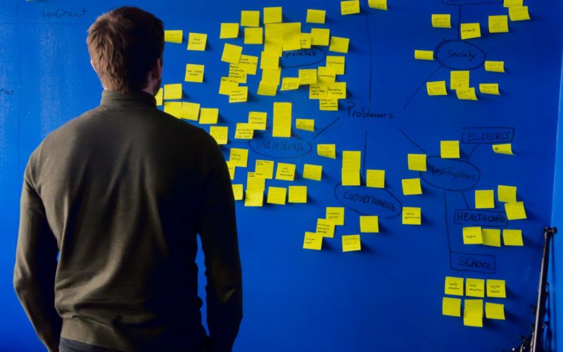 man in gray long sleeve shirt standing in front of blue and yellow puzzle mat