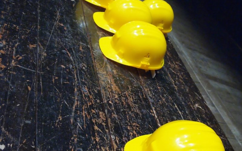 five yellow hard hats on gray surface