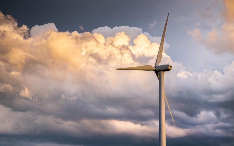 white wind turbine under white clouds and blue sky during daytime