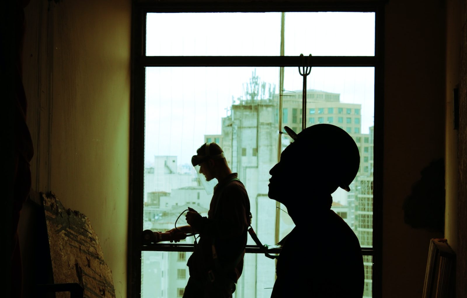 two men wearing hard hat standing near clear glass window